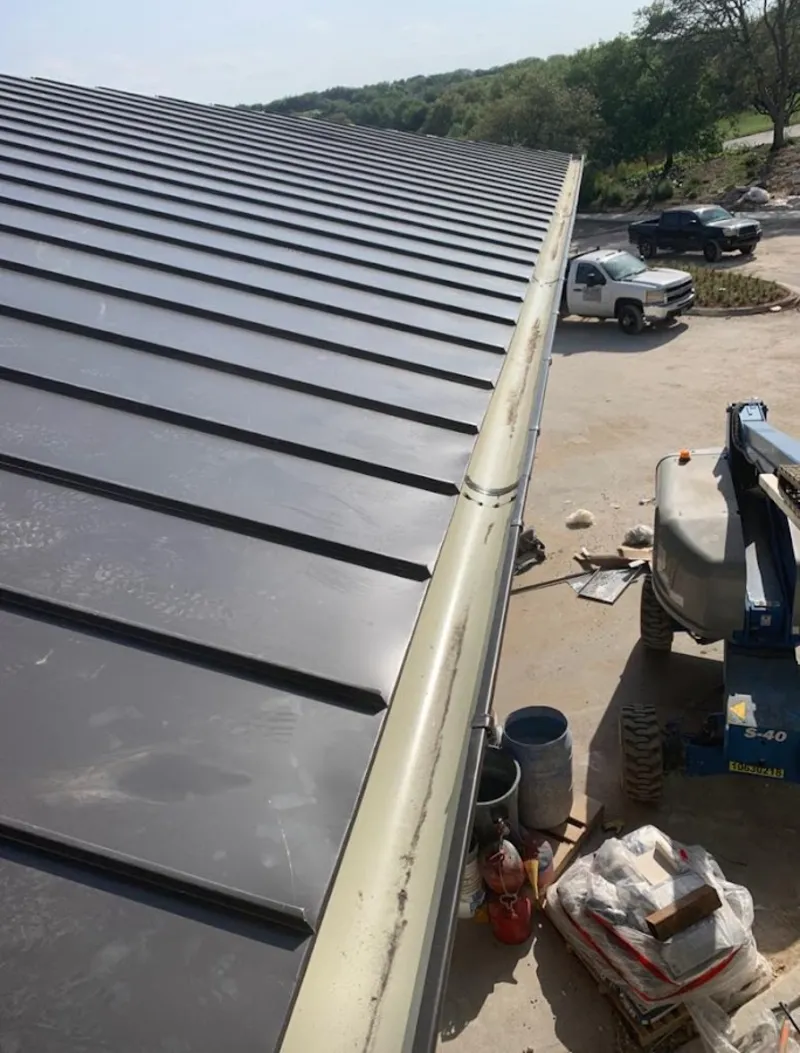 Standing seam panel and gutter detail on a metal roofing jobsite in Hampton